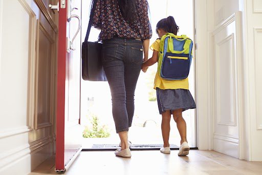 Close Up Of Mother And Daughter Leaving For School