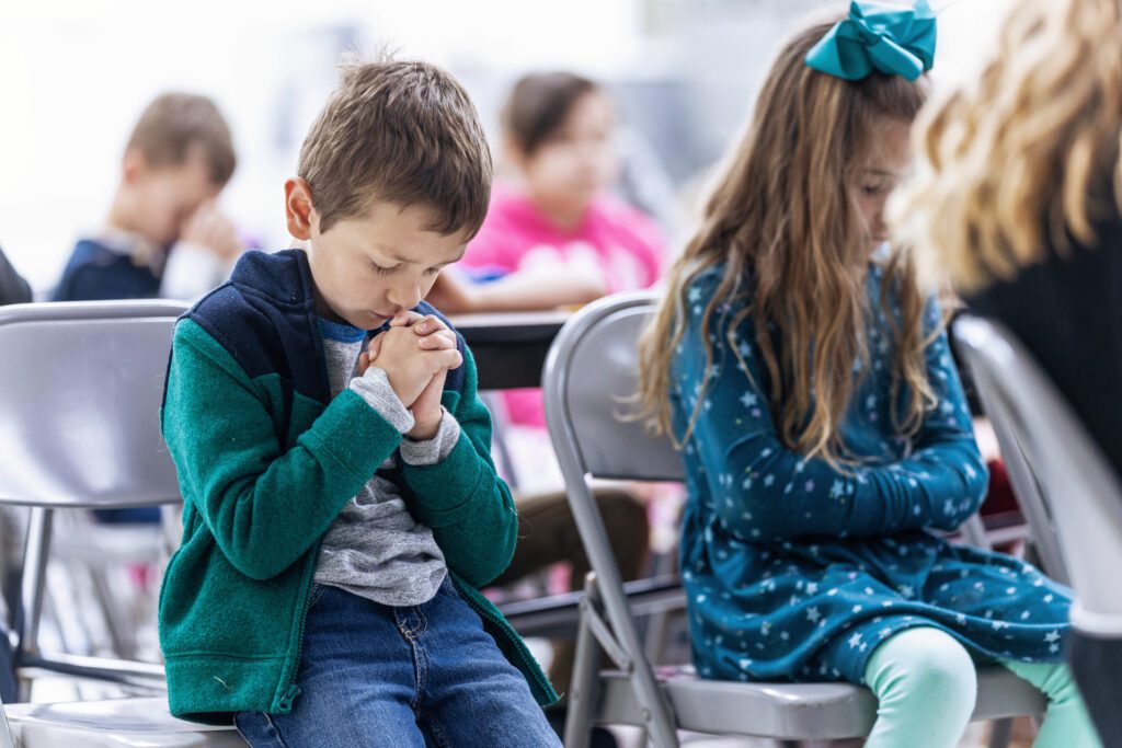Christian school student praying in classroom